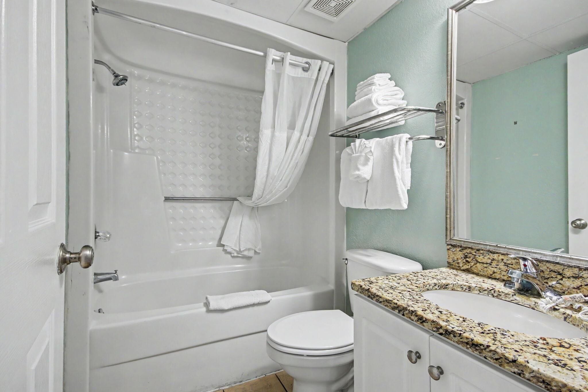 A bathroom with a bathtub, toilet, and sink.