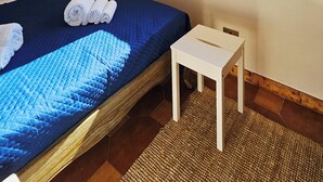 A bedroom with a bed, a bedside table, a window, and an air conditioning unit. - Attic room a stone's throw from the harbor. Private parking. (Livorno)