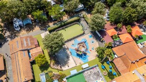 Ein Luftbild einer Wohngegend mit Spielplatz, Schwimmbad und Tennisplatz.