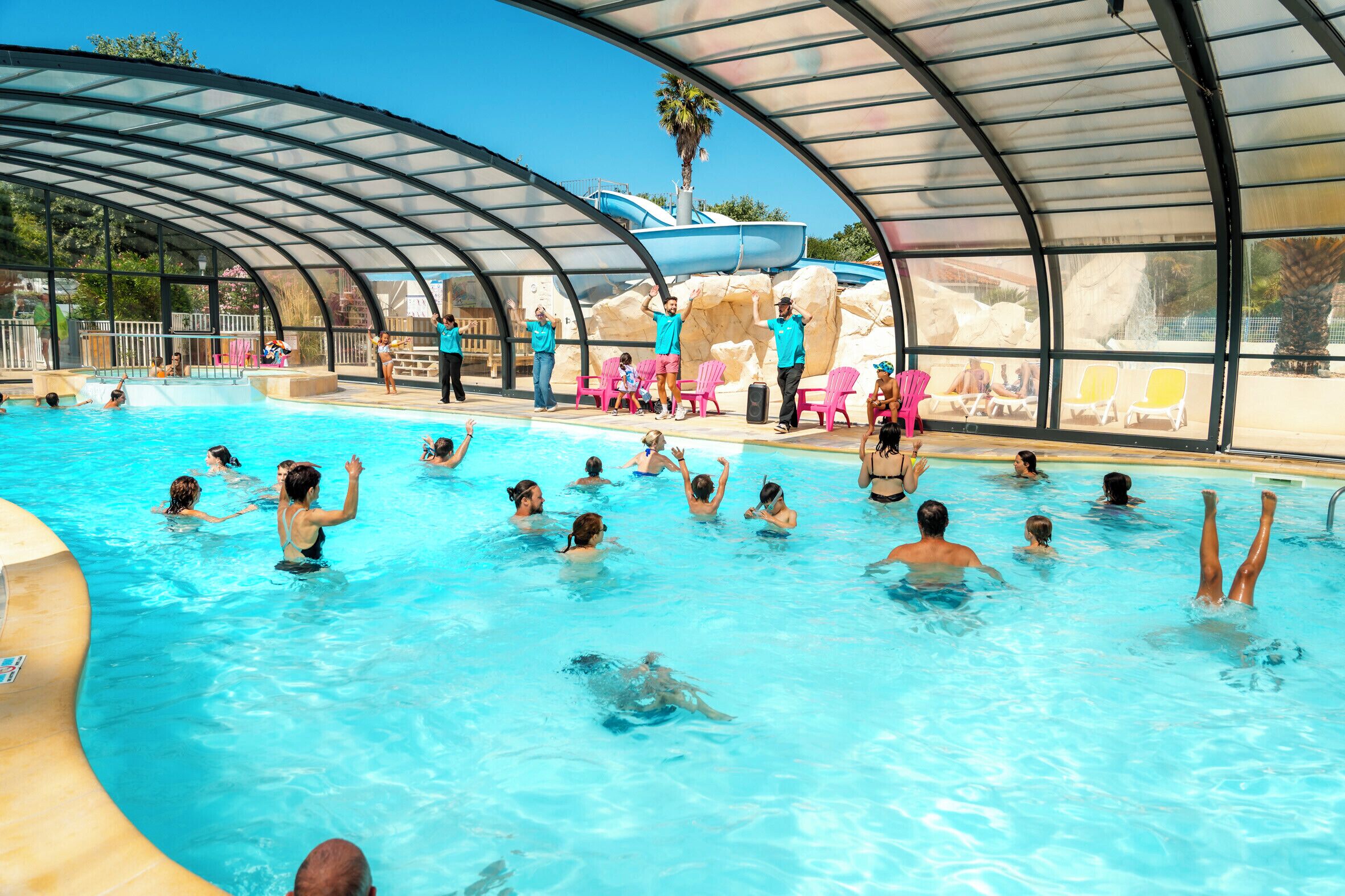 A swimming pool with a covered area and lounge chairs.