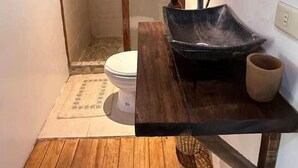 A bathroom with a wooden vanity, a black sink, and a toilet. - AC Room with Balcony and Nature Views (Santa María Tonameca)
