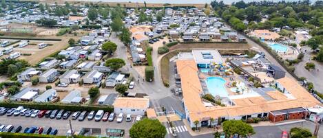 A caravan park with multiple caravan sites, a swimming pool, and a parking area.