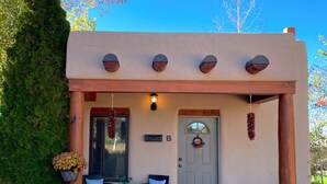 A house with a porch, a door with a wreath, a mailbox, and a potted plant. - Horse Ranch Casita #B (Santa Fe)