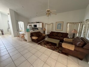 Ein Wohnzimmer mit einer Couch, einem Couchtisch und einem Essbereich mit Stühlen und einem Tisch.
