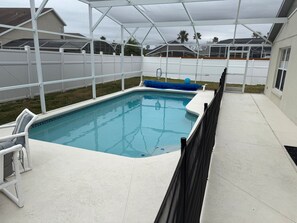 A rectangular swimming pool with a white tiled edge and a blue accent. - Beautiful Home In Hampton Lakes (Davenport)