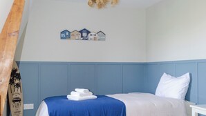 A bedroom with two beds, a wooden ceiling beam, a wall-mounted decoration, and a surfboard. - La Forge by L'Ora, a haven of peace 2 steps from the center of Cassel (Cassel)