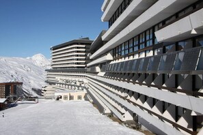 A modern hotel with a unique zigzag architectural design, featuring multiple balconies and large windows. - 10m from ski slopes, 16th floor, balcony, ski locker, 37m², Les Menuires (Les Menuires)