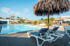 A swimming pool with lounge chairs and a water slide. - Carva - Confort 2 TV - 5p (16) (La Guérinière)