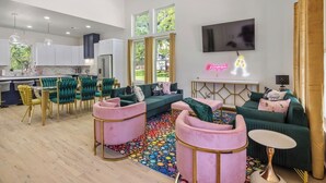 Una sala de estar moderna con un sofá, sillas y un televisor.