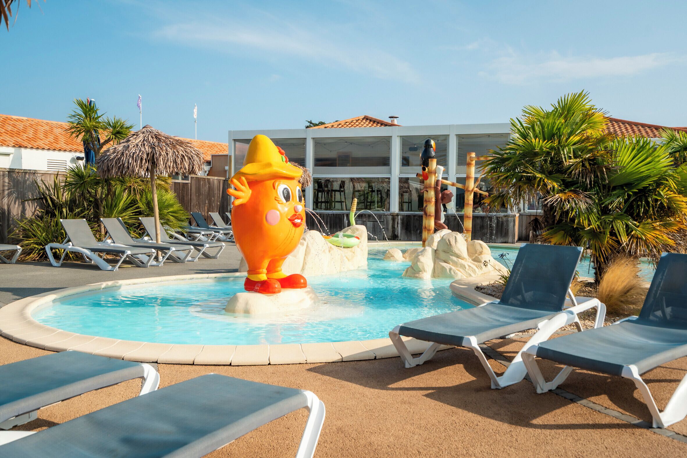 Una piscina amb gandules i un personatge inflable gran.