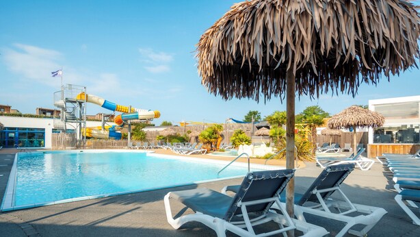 A swimming pool with lounge chairs and a water slide. - Carva - Confort 2 TV - 5p (57) (La Guérinière)