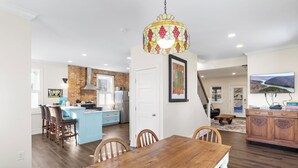 A spacious kitchen with a central island, a dining area with a wooden table, and a living room with a television. - Clever Rabbit- Raystown Lake-Seven Points- Aunt Susies (Hesston)