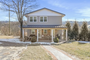 A two-story house with a covered porch, a grill, and a small garden area. - Clever Rabbit- Raystown Lake-Seven Points- Aunt Susies (Hesston)