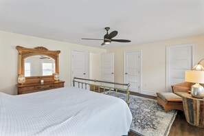 A bedroom with a bed, a ceiling fan, a dresser, a mirror, and a chair. - Clever Rabbit- Raystown Lake-Seven Points- Aunt Susies (Hesston)