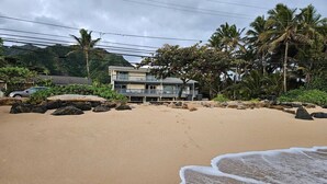 Une plage avec un bâtiment en arrière-plan.