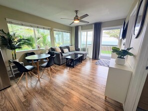 A spacious living area with a sofa, chairs, a coffee table, and a ceiling fan. - Oceanfront Hauula Home - North Unit B - 30+ Days (Hauula)