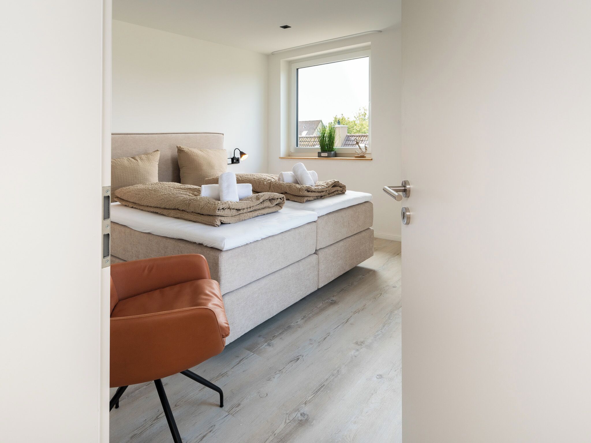 Una camera da letto moderna con un letto, una sedia e una finestra.
