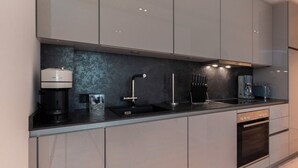 A modern kitchen with a built-in dishwasher, a coffee maker, and a toaster. - Inseltörn apartment 3 <br>Spacious apartment for 6 people & entry to the swimming pool (Büsum)