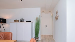 A modern kitchen with white cabinets, a wooden countertop, and a potted plant. - Inseltörn apartment 3 <br>Spacious apartment for 6 people & entry to the swimming pool (Büsum)