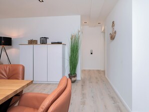A modern kitchen with white cabinets, a wooden countertop, and a potted plant. - Inseltörn apartment 3 <br>Spacious apartment for 6 people & entry to the swimming pool (Büsum)