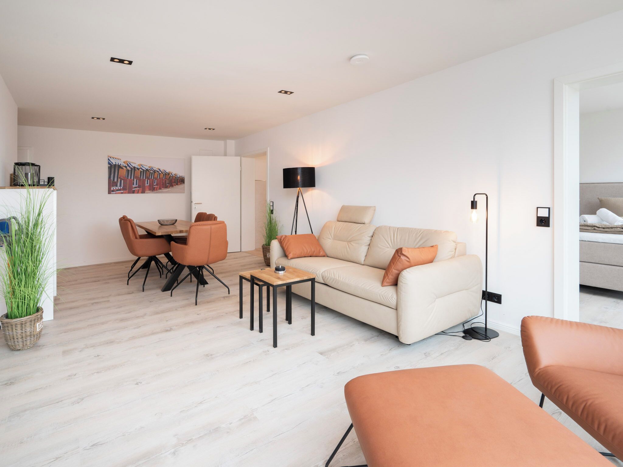 A modern living room with a sofa, a coffee table, and a dining area with chairs.