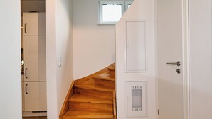 A staircase leading to a second floor with a white door and a window above it. - Vacation home "Noordkant 17" with its own sauna (Büsum)