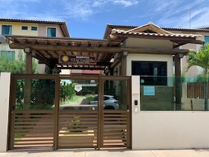 A gated entrance to a residential property named "Residencial TACCIMIRIM" with a pergola above the gate. - Beachfront Paradise in Condo w/ Pool in Itacimirim - Rsvs (Camaçari)
