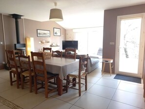 Un comedor con una mesa, sillas, televisor y un sofá.
