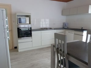 A kitchen with white cabinets, a microwave, an oven, a gas stove, and a coffee maker. - Renovated house near beach, with parking, ideal for 4/6 people (La Tranche-sur-Mer)