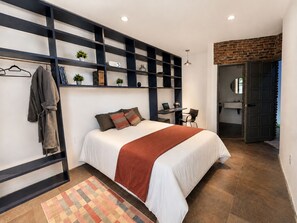 Un dormitorio moderno con cama, escritorio y armario.