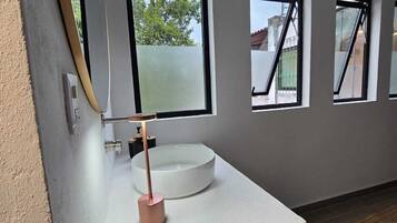 Habitación cuádruple Deluxe, vista al patio | Baño | Regadera, secadora de cabello, toallas, jabón