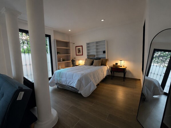 A bedroom with a bed, bedside tables, a wardrobe, and a large mirror. - Casa Puerto Siete8 (Mexico City)