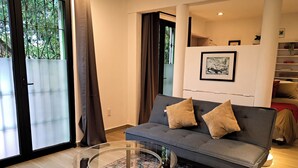 A modern living room with a grey sofa, two cushions, a glass coffee table, and a patterned rug. - Casa Puerto Siete8 (Mexico City)