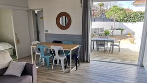 Ett modernt vardagsrum med en soffa, ett soffbord och en matplats med stolar och ett bord.