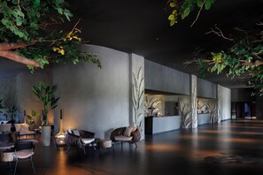 A modern lobby with seating, a reception desk, and indoor plants. - Lopesan Caoba Lagoon Resort Spa & Casino - All Inclusive (Punta Cana)