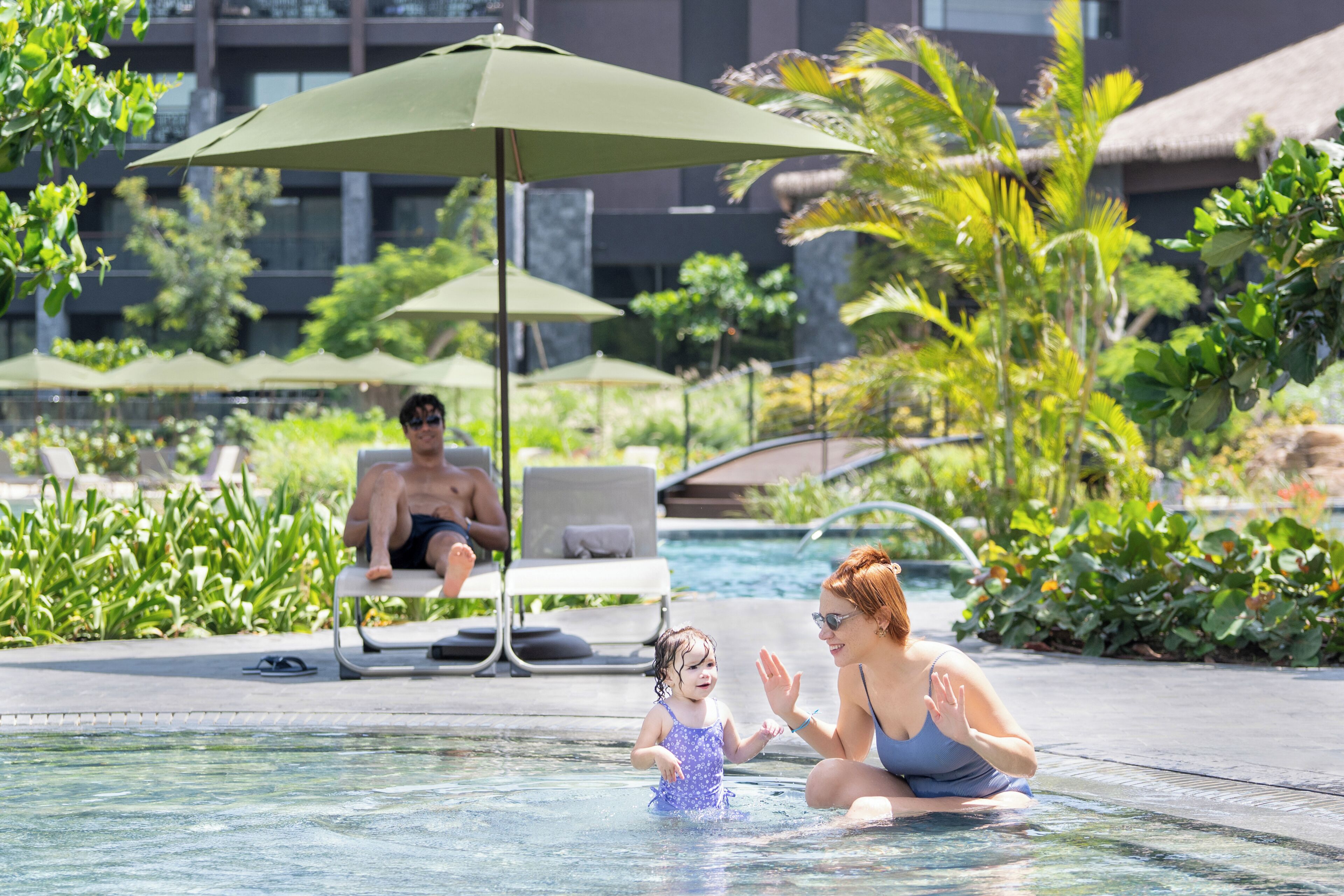 A pool area with lounge chairs and umbrellas.