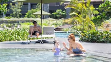 A pool area with lounge chairs and umbrellas.