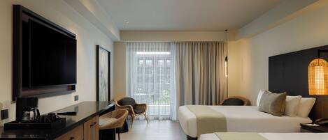 Una habitación de hotel con una cama, un escritorio con televisor, una silla y una ventana con cortinas.