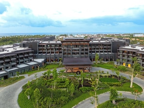 A modern hotel complex with multiple buildings, a central courtyard, and a view of the ocean. - Lopesan Caoba Lagoon Resort, Spa & Casino (Punta Cana)