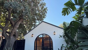 A house with a large tree, a white exterior, and a large arched window. - Brand New Moderne house with Private Garden Prime LA Location (Los Angeles)