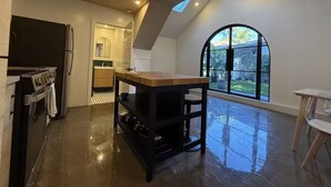 A spacious kitchen with a central island, a large window with a view, and a skylight. - Brand New Moderne house with Private Garden Prime LA Location (Los Angeles)