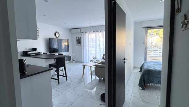 Una cucina moderna con zona pranzo, televisione e vista esterna.