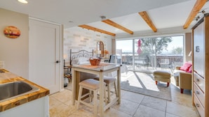 A kitchen with a wooden countertop, a sink, and a table with stools. There is a window with a view of the outside. - Hike & Explore Dtwn Tucson! Relaxing Solo Escape (Tucson)