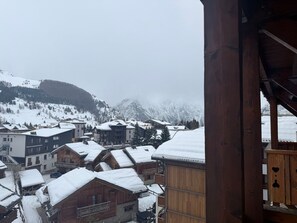 A snowy mountain village with wooden buildings and a view of snow-covered mountains. - Les 2 Alpes, apt for 4, 25 m² (Les Deux Alpes)