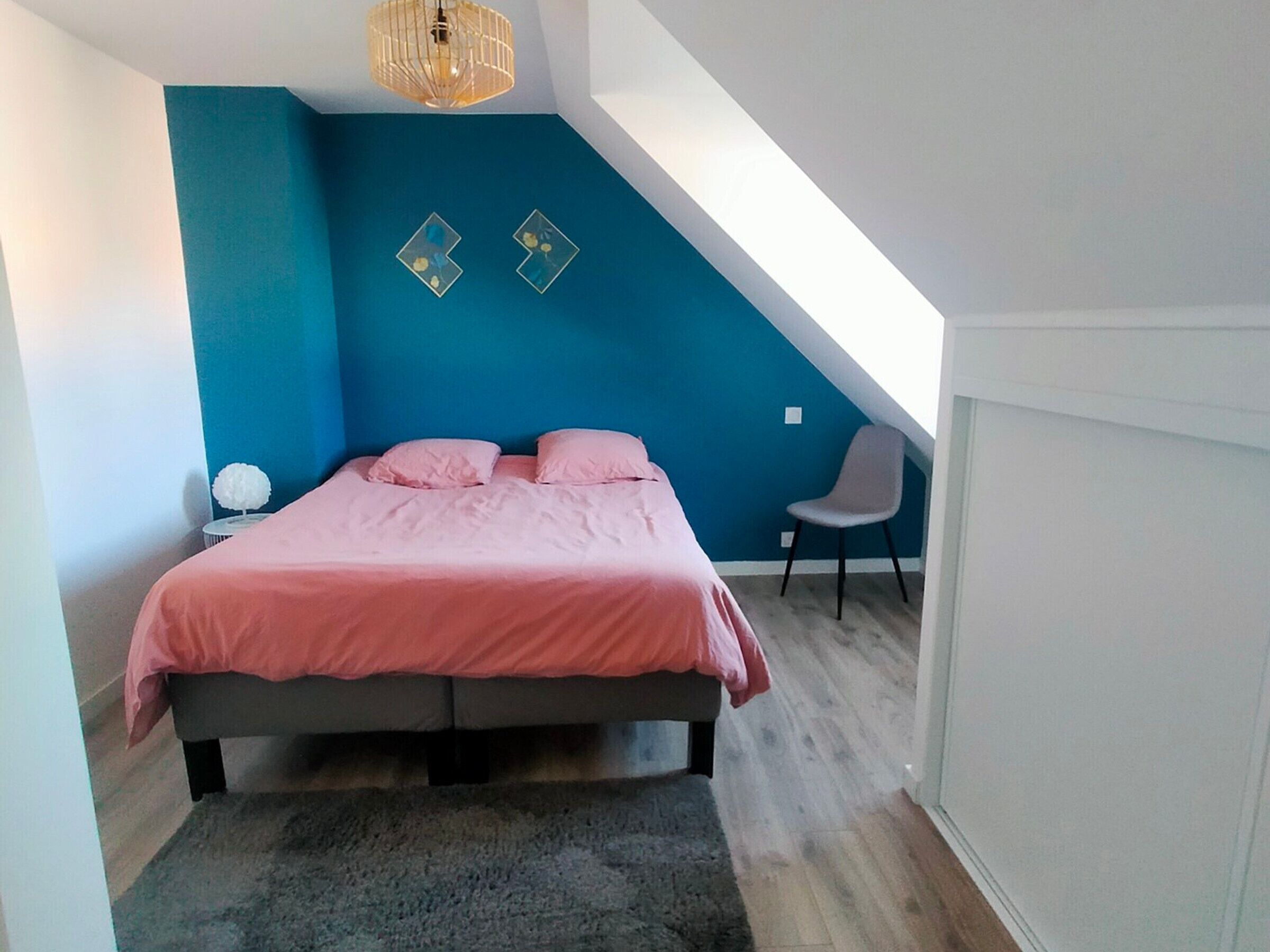 Ein Schlafzimmer mit Bett, Stuhl und Deckenleuchte.