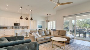 A modern living room with a sofa set, a coffee table, and a dining area with chairs. - Hot Tub & Community Perks! Sleek Goodyear Retreat (Goodyear)