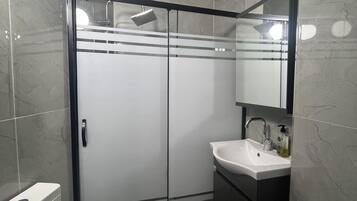 Klassieke kamer | Badkamer | Een douche, handdoeken, zeep, shampoo