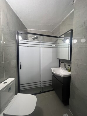 Klassieke kamer | Badkamer | Een douche, handdoeken, zeep, shampoo