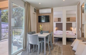 Ett modernt hotellrum med en matplats, en säng och en TV.