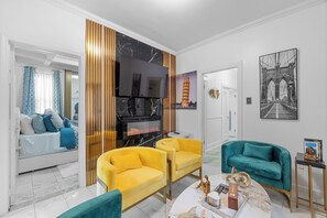 Una sala de estar moderna con un sofá, sillones, una chimenea y obras de arte en las paredes.